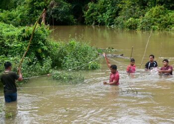 PENDUDUK kampung tidak melepaskan peluang memasang pukat di kawasan ditenggelami air di sekitar Kampung Banggol Katong, Kuala Terengganu, semalam. - UTUSAN/PUQTRA HAIRRY ROSLI