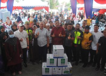 AHLI Dewan Undangan Negeri (ADUN) Duyong, Datuk Mohd. Noor Helmy Abdul Halem bersama penerima bantuan Jelajah Peduli Ummah di tapak parkir Masjid Jamek Laksamana Hang Tuah, Duyong, Melaka. - UTUSAN/AMRAN MULUP