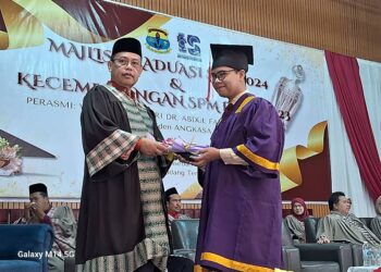 ABDUL FATTAH Abdullah menyampaikan sijil graduasi kepada calon SPM Sekolah Menengah Kebangsaan Padang Tengku di Lipis, Pahang. - FOTO/SALEHUDIN MAT RASAD