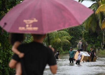 SEKUMPULAN kanak-kanak mengambil kesempatan bermain banjir di Kampung Rawai, Marang, hari ini. - UTUSAN/PUQTRA HAIRRY