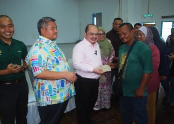 SHAMSUL ISKANDAR Mohd. Akin menyampaikan sumbangan wang tunai kepada mangsa banjir di Dewan Bunga Tanjung, Tanjung Minyak, Melaka. - UTUSAN/AMRAN MULUP