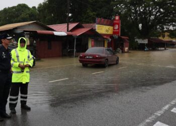 MOHD.  Khairi Khairudin (kiri) meninjau kawasan banjir di Kampung Padang Luas, Besut, hari ini. - UTUSAN/PUQTRA HAIRRY ROSLI