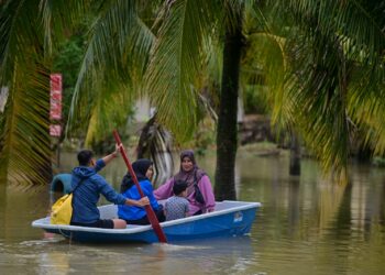 PENDUDUK menggunakan sampan keluar dari rumah berikutan banjir di Kampung Menerong, Kuala Berang, semalam. - UTUSAN/PUQTRA HAIRRY ROSLI