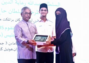 AL-SULTAN Abdullah Ri'ayatuddin Al-Mustafa Billah Shah (kiri) berkenan mengurniakan platform GNIUS dan tablet kepada pelajar terpilih di Hotel Grand Darul Makmur di Kuantan, Pahang. - FOTO/SHEIKH AHMAD RAZIF