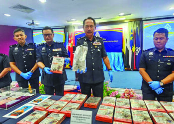 JAUTEH Dikun (dua kanan) menunjukkan bungkusan digunakan untuk menyimpan dadah semasa sidang akhbar di IPK Sabah di Kota Kinabalu semalam.