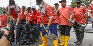 ALEXANDER Nanta Linggi (depan) menyertai program CSR Bersama Kementerian Kerja Raya (KKR), Jabatan Kerja Raya (JKR) dan syarikat Belati Wangsa (M) Sdn. Bhd. Bagi Kesiapsiagaan Monsun Timur Laut di Jalan Ipoh-Lumut, Seri Iskandar hari ini. - UTUSAN/MUHAMAD NAZREEN SYAH MUSTHAFA