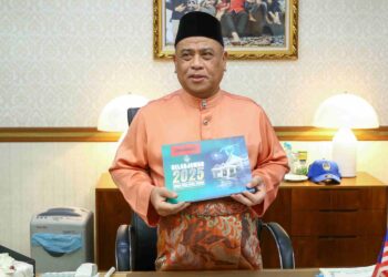 SAARANI Mohamad menunjukkan buku Belanjawan Perak 2025 sebelum membentangkannya pada sidang dewan negeri semalam. – UTUSAN/MUHAMAD NAZREEN SYAH MUSTHAFA