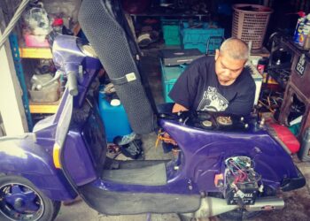 Mohamad Azarudeen sedang membaik pulih Vespa di bengkelnya 
di Taman Seri Cheeding.-– Utusan/Abdul Razak Idris