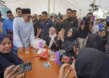 ANWAR Ibrahim beramah mesra dengan orang ramai ketika hadir meluangkan masa menjamu selera di Medan Selera Presint 9, Putrajaya, semalam. – UTUSAN/FAISOL MUSTAFA