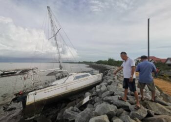 KEADAAN bot yang dipukul ribut dan terdampar di muara Sungai Perak di Kampung Sungai Tiang di Bagan Datuk kelmarin. – UTUSAN/AIN SAFRE BIDIN