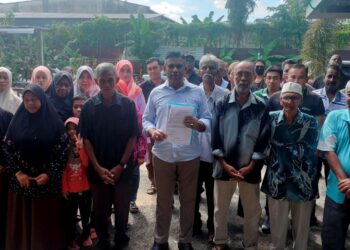 MOHD. Ridzuan Abdullah (tengah) bersama penduduk merayu kerajaan negeri membantu menyelesaikan  isu geran tanah kediaman mereka di Kampung Setia Jaya Kamunting di Taiping kelmarin. – UTUSAN/WAT KAMAL ABAS