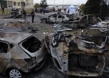 PENDUDUK tempatan memeriksa kereta yang terbakar di halaman bangunan kediaman berikutan serangan dron di Odesa, Ukraine.-AFP