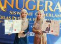 SITI Nurhaziqah Hamid (kanan) bersama adiknya, Siti Nurfahana menerima insentif wang tunai sebanyak RM5,000 sempena Anugerah Siswazah Cemerlang Kelas Pertama Negeri Sembilan Siri Keempat 2024 
di Seremban, semalam.