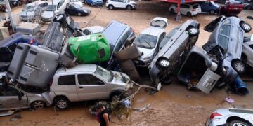 TIMBUNAN kenderaan yang diselaputi lumpur selepas dihanyutkan banjir kilat di jalan Paiporta, kawasan Valencia, timur Sepanyol.- AFP