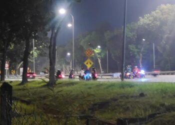 SEKUMPULAN ‘mat rempit’ yang dirakamkan berkumpul sebelum mula berlumba haram di susur keluar dekat Sungai Merab Jaya, Sepang. - UTUSAN/AMREE AHMAD