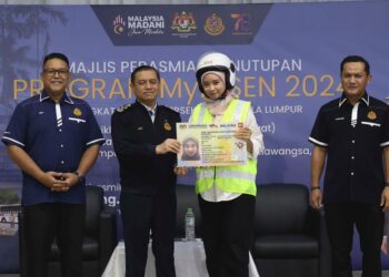 AEDY Fadly Ramli menyerahkan topi keledar dan ‘mock’ lesen kepada penerima di Perasmian Penutup Program MyLesen 2024 di Dewan Pusat Komuniti Setiawangsa, Kuala Lumpur, hari ini