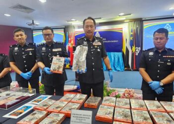 JAUTEH Dikun (dua kanan) menunjukkan bungkusan yang digunakan untuk menyimpan dadah semasa sidang akhbar di IPK Sabah di Kota Kinabalu hari ini.