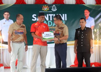 SAIFUDDIN Nasution Ismail (dua kiri) menyerahkan sumbangan bakul makanan kepada salah seorang penerima selepas merasmikan Program Satu Pemimpin Satu Kampung (Santuni Madani) di Sekolah Menengah Kebangsaan (SMK) Tanjong Bunga, Pasir Mas, Kelantan hari ini.-UTUSAN/KAMARUL BISMI KAMARUZAMAN.