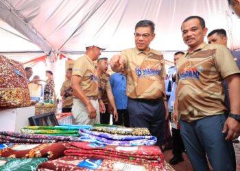 SAIFUDDIN Nasution Ismail (dua kanan) melihat batik yang dihasilkan oleh penghuni penjara selepas merasmikan Program Satu Pemimpin Satu Kampung (Santuni Madani) di Sekolah Menengah Kebangsaan (SMK) Tanjung Bunga, Pasir Mas, Kelantan hari ini-UTUSAN/KAMARUL BISMI KAMARUZAMAN.