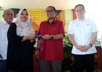 MOHAMED KHALED Nordin menyampaikan sumbangan zakat wakalah kepada seorang penerima sambil diperhatikan oleh Ketua Pegawai Eksekutif BHPetrol Ir. Azizul Azily Ahmad di Masjid Muhajirin, Masai, Johor Bahru./pix RAJA JAAFAR ALI