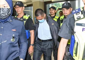 MOHD. Adil Mat Awang Ghani dikawal anggota polis ketika hadir di Mahkamah Majistret Kuala Lumpur  hari ini. UTUSAN/SYAKIR RADIN