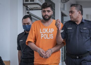 MAHER Al-Ali diiringi anggota polis selepas dituduh atas kesalahan memiliki satu pasport palsu Britain di Mahkamah Sepang. - UTUSAN/FAIZ ALIF ZUBIR