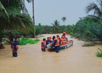 ANGGOTA APM menyelamatkan mangsa yang terjejas banjir di kawasan Gemencheh, Tampin pagi tadi.