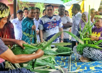 ANTHONY Loke Siew Fook melihat pembuatan anyaman kraftangan oleh penduduk pada Majlis Penyerahan Kampung Angkat Madani Kementerian Pengangkutan di Kampung Orang Asli Ngoi-Ngoi di Seremban hari ini.-UTUSAN/MOHD. SHAHJEHAN MAAMIN.