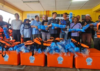 MUHAMMAD Faiz Fadzil (tengah) menyampaikan bantuan kemudahan dan peralatan perikanan nelayan pantai pada Program Rahmah Mesra Madani Bersama Nelayan PNK Marang di Marang, hari ini.  - UTUSAN/ZAID MOHD.NOOR