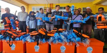 MUHAMMAD Faiz Fadzil (tengah) menyampaikan bantuan kemudahan dan peralatan perikanan nelayan pantai pada Program Rahmah Mesra Madani Bersama Nelayan PNK Marang di Marang, hari ini.  - UTUSAN/ZAID MOHD.NOOR