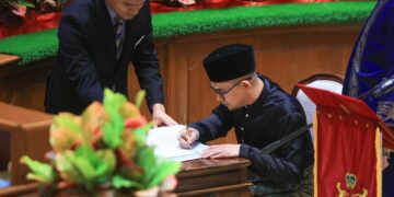 MOHD. Azmawi Fikri Abdul Ghani menurunkan tandatangan selepas selepas mengangkat sumpah sebagai ADUN Nenggiri semasa Sidang DUN Kelantan di Kota Darulnaim, Kota Bharu, Kelantan.-UTUSAN/KAMARUL BISMI KAMARUZMAN.