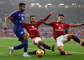 DUA pemain pertahanan Manchester United,  Lisandro Martinez (kanan) dan Noussair Mazraoui cuba menghalang pemain Leicester, James Justin  dalam aksi Liga Perdana Inggeris di Old Trafford. - AFP