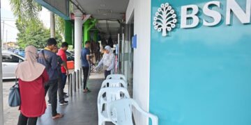 SEBAHAGIAN penerima Sumbangan Tunai Rahmah (STR) beratur untuk mengambil bantuan tersebut di Bank Simpanan Nasional (BSN). - Gambar hiasan