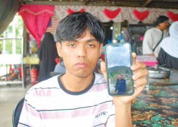 MUHAMMAD SYUKRI Mokthar menunjukkan gambar Allahyarham Mokthar Othman di Hutan Perca, Alor Gajah, Melaka. – UTUSAN/AMRAN MULUP