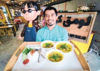 SHAMSUL Munir Safini (kanan) bersama model karikatur terkenal, Ujang - Aku Budak Minang yang diletakkan di Lomaq Coffee, Seberang Jaya, Pulau Pinang.  – mingguan/IQBAL HAMDAN