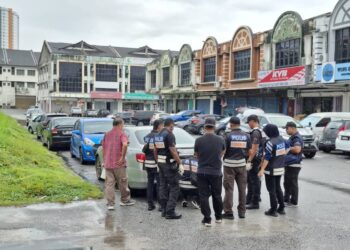 ANGGOTA polis menjalankan pemeriksaan pada kenderaan milik mangsa yang membawa beg berisi empat kilogram barang kemas dalam kejadian samun di Ipoh hari ini.  - UTUSAN