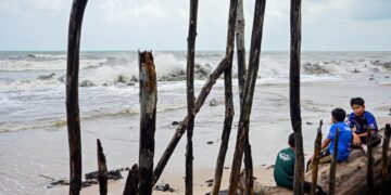 TIGA kanak-kanak melihat keadaan ombak besar di pantai Kampung Pengkalan Maras, Kuala Nerus, hari ini. - UTUSAN / PUTRA HAIRRY ROSLI