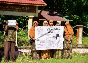 PENDUDUK memegang sepanduk menuntut keadilan buat semua mangsa yang terkorban dalam tragedi Tak Bai di wilayah Narathiwat, selatan Thailand. - AFP