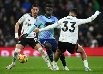 BUKAYO Saka (tengah) disekat oleh pertahanan Fulham pada aksi Liga Perdana Inggeris (EPL) di Craven Cottage, hari ini. - AFP