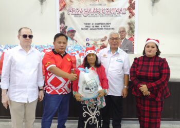 HASSAN Abdul Karim (tengah) bergambar bersama penerima sumbangan pada Majlis Sambutan Perayaan Krismas Bersama Masyarakat Sarawak Pasir Gudang di Taman Megah Ria, Masai, di sini, hari ini.