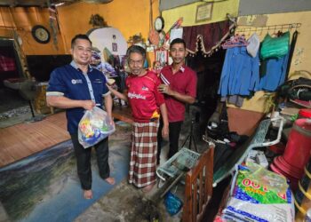 KAMARUL Azman Khamis (kiri) menyampaikan sumbangan kepada mangsa banjir di Kampung Pokka Kuala Nerang, hari ini.-UTUSAN