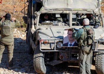 TENTERA Israel menggulung potret Bashar al-Assad ketika membuat rondaan berhampiran perkampungan Druze Majdal Shams di Dataran Tinggi Golan.-AFP