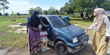 ZURAINI Kamal (kanan) meninjau keadaan kereta digunakan Nor Aza Hamzah (kiri) ketika mengunjungi kediamannya di Kampung Senjana, Mukim Titi Gajah, Alor Setar, Kedah, semalam.