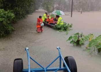 ANGGOTA polis membantu menyelamat mangsa banjir ke pusat pemindahan sementara di Tanah Merah. - IHSAN POLIS