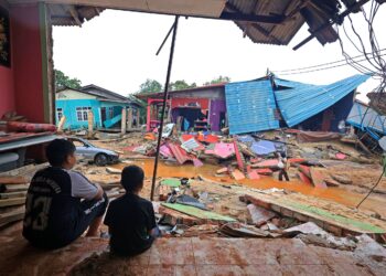 DUA Kanak-kanak lelaki melihat rumah yang musnah akibat banjir di Kampung Jubakar Pantai, Tumpat di Kelantan semalam. 
– UTUSAN/KAMARUL BISMI KAMARUZAMAN