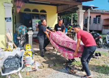 PENDUDUK membersihkan rumah mereka yang terjejas akibat dinaiki air banjir di Kampung Paya, Balai Besar, Dungun, Terengganu, semalam. – UTUSAN/NIK NUR IZZATUL HAZWANI NIK ADNAN