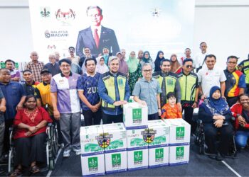 FAHMI Fadzil  bersama penerima bantuan pada program Jelajah Peduli Ummah Lembah Pantai di IWK Eco Park, Pantai Dalam, semalam. – UTUSAN/SADDAM YUSOFF