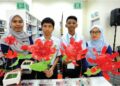 JOELSON Jefri (dua, kiri) dan Muhammad Haziq Han Hamzah (dua,i kanan) menunjukkan ‘Fairy Lamp’ yang dihasilkan daripada botol plastik terpakai bersama guru pembimbing, Nur Shasabila Shamsudin (kiri) dan Nurfarahiyah Mahmud (kanan) di Universiti Teknologi Mara (UiTM), Pasir Gudang.