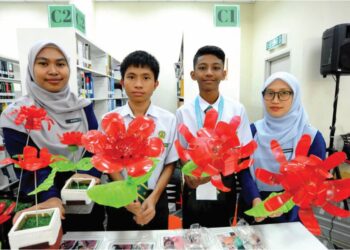 JOELSON Jefri (dua, kiri) dan Muhammad Haziq Han Hamzah (dua,i kanan) menunjukkan ‘Fairy Lamp’ yang dihasilkan daripada botol plastik terpakai bersama guru pembimbing, Nur Shasabila Shamsudin (kiri) dan Nurfarahiyah Mahmud (kanan) di Universiti Teknologi Mara (UiTM), Pasir Gudang.