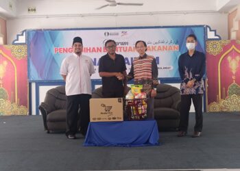 ILYAS Helmi Mohd. Yusof (kiri)  di majlis penyampaian bantuan barangan makanan kepada asnaf di Kuala Terengganu hari ini. - UTUSAN/KAMALIZA KAMARUDDIN